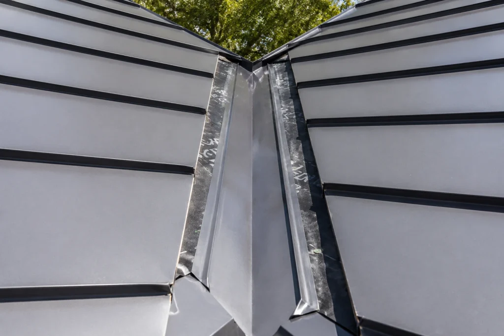properly installed metal roof valley showing flashing and drainage channel