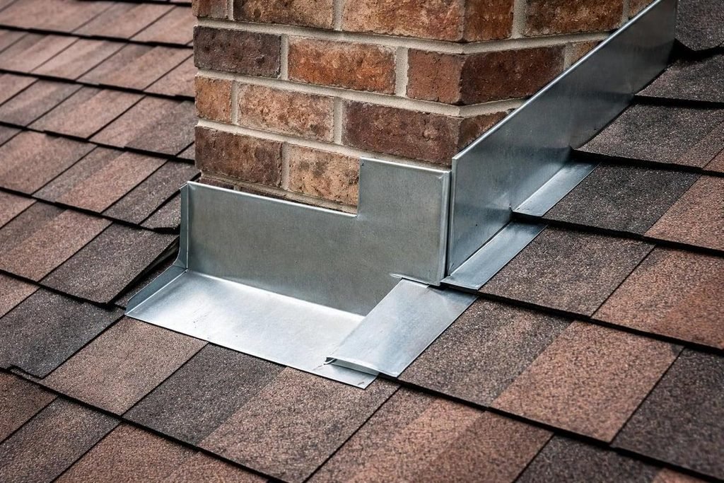 Chimney flashing replacement showing metal step and counter-flashing on a shingle roof
